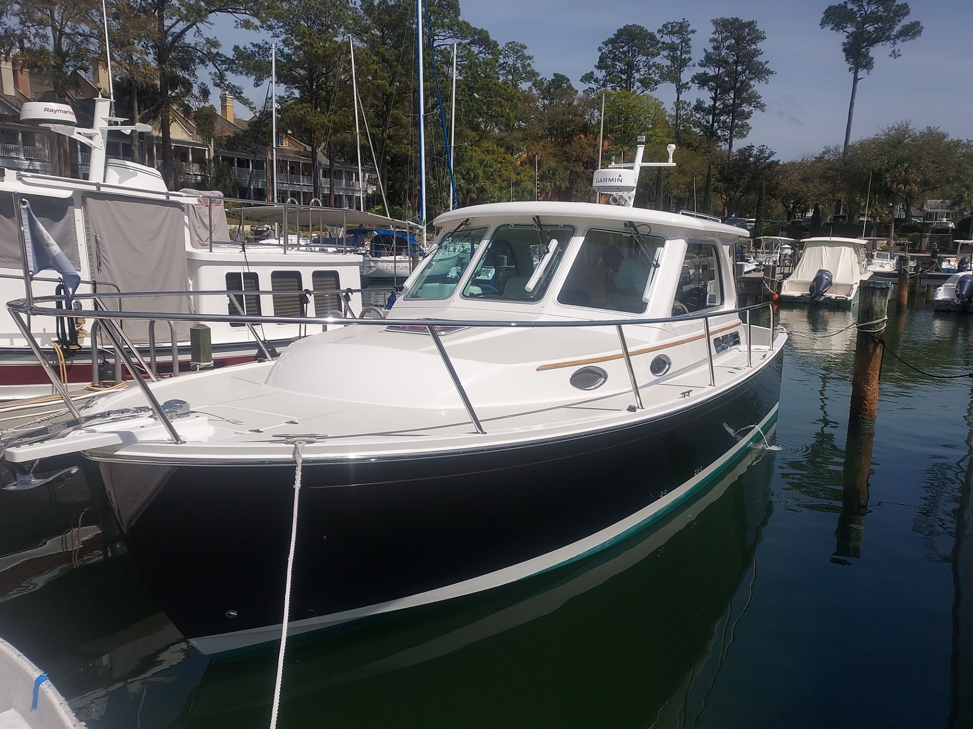 A dark-hulled cruiser tied up at a Hilton Head marina, hull and brightwork gleaming