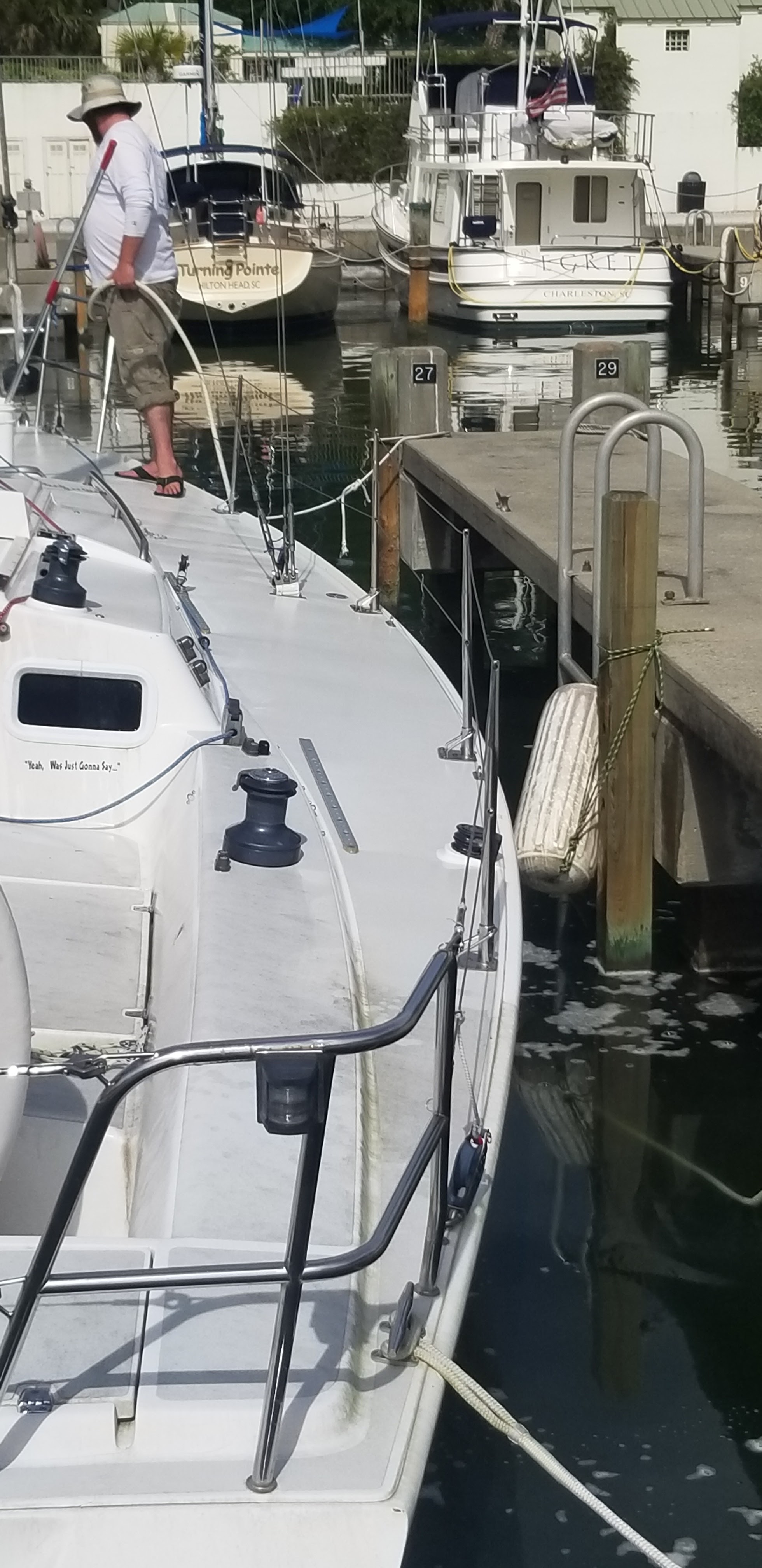 One of our crew hosing down the deck of a sailboat at the dock